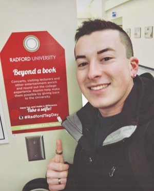 TAG Day winner Ivan Thirion Romo takes a selfie with one of the TAGs posted on campus.